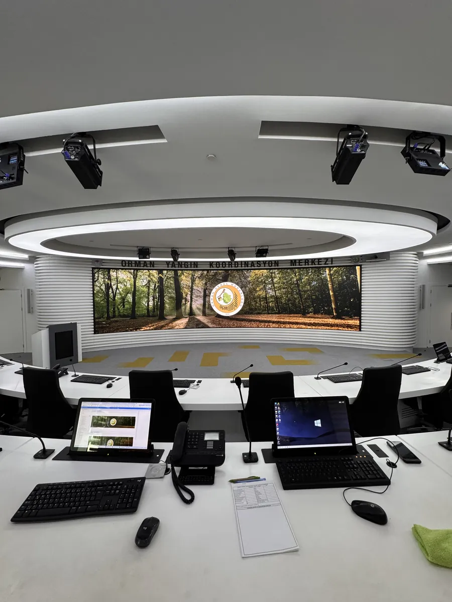 Operatör iş istasyonları ve arkada kavisli LED ekran
